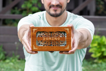 Close-up shot of a man playing dominoes in the yard on a beautiful summer day	