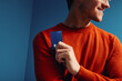 © Jacob Lund - Man holding bank card in vibrant color blocking studio shot