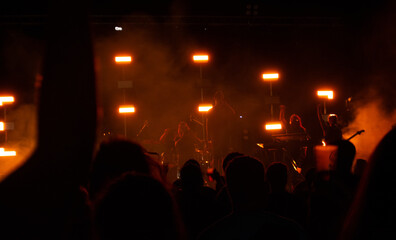 rock concert with red lights from behind with colored led lights