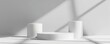 © Emma - White cylindrical podiums set against a plain background, minimalist, soft shadows, professional product mockup design