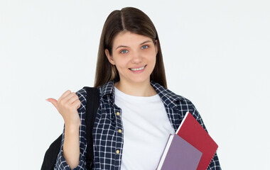 Wall Mural - Hey look. Smiling pretty female model pointing fingers left at empty space and inviting to check it out, showing advertisement on white background. Girl with notepads in hands.