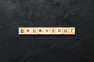 BEHAVIOUR word written on wood block. BEHAVIOUR text on cement table for your desing, concept