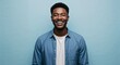© Arceli - Joyful young African American man with short hair wearing casual shirt on plain light blue background