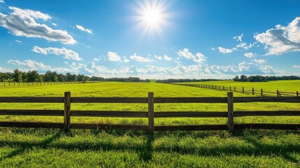 Rustic wooden fence and green fields under a bright sunny sky on an animal farm, lots of copy space available