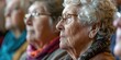 © RealPeopleStudio - A close-up of an elderly audience at a community center, listening intently to a guest speaker