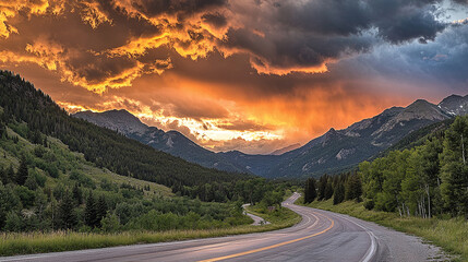 A winding asphalt highway stretching through lush green mountains under a dramatic sunset sky, with vibrant clouds, capturing the beauty of a serene road journey.