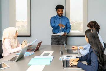 Group of multicultural business people in a discussion during a business meeting in a conference room. Happy business people, men and women, collaborating and working towards their shared goals