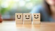© Artyom - Three smiling wooden cube faces on table representing happiness and unity