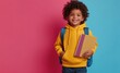 © grigoryepremyan - A cheerful African American schoolboy with backpack on a pastel background.