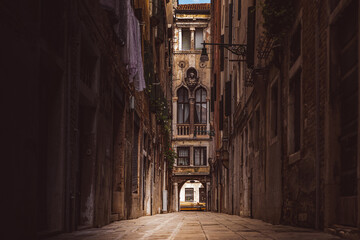 Wall Mural - A narrow street in Venice surrounded by historic buildings, leading to a decorative facade. A place full of Venetian charm, perfect for exploring the city’s secrets.