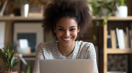 Sticker - A smiling woman with curly hair engages with a laptop in a cozy, well-decorated workspace, creating a warm and inviting atmosphere.