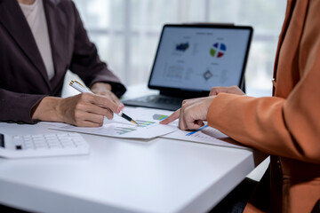 Business team working together on a new project with graphs and using a laptop at the office