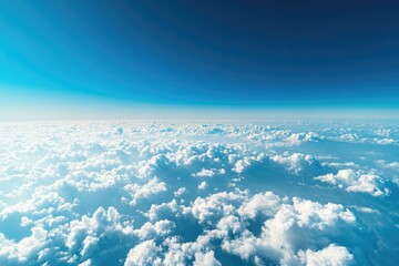 Sky view from a plane with fluffy clouds below and a clear blue sky above, capturing the peaceful feeling of flight