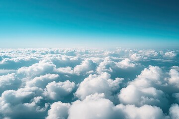 Sky view from a plane with fluffy clouds below and a clear blue sky above, capturing the peaceful feeling of flight