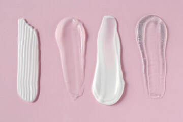 Poster - Smears of different cosmetic products on pink background, flat lay