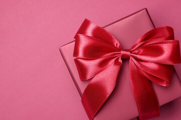 Poster - Gift box with bow on pink background, top view. Space for text