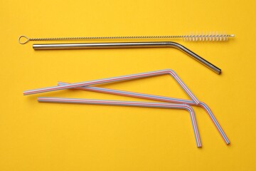 Wall Mural - Different drinking straws and cleaning brush on yellow background, flat lay