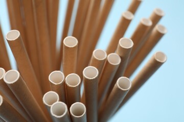 Wall Mural - Bamboo drinking straws on light blue background, closeup