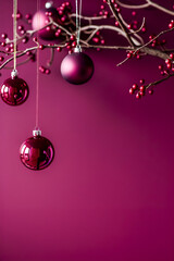Wall Mural - Ornate burgundy Christmas background. Christmas decorations with deep red ornaments hanging on branches adorned with berries on a rich burgundy background with copy space.