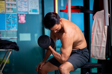 A strong Asian man is exercising to build muscle..