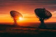 © Olsek - Two satellite dishes stand against a vibrant sunset. The sun casts warm tones across the sky and landscape. A beautiful blend of technology and nature. Generative AI