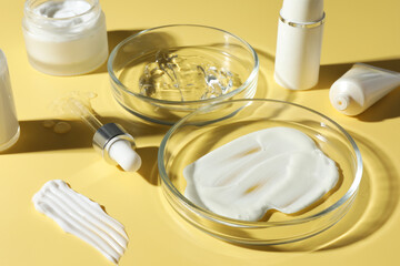 Wall Mural - Petri dishes with cosmetic products and pipette on yellow background, closeup