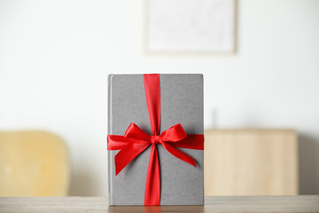 Wall Mural - Hardcover book with ribbon as gift on wooden table indoors