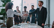 © ihorvsn - Female and male shaking their hands. Standing in front of group of consultants. Everyone clapping. Happy about positive ending to meeting. Smiling with joy. Partnership and collaboration in business.