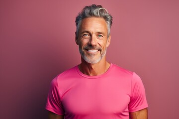 Canvas Print - Portrait of a glad man in his 50s wearing a moisture-wicking running shirt isolated in minimalist or empty room background