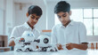 © Suralai - two modern small indian students doing a robotic project. the students must wear white shirt, in classroom