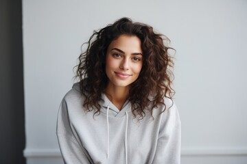 Poster - Portrait of a satisfied woman in her 20s dressed in a comfy fleece pullover isolated on minimalist or empty room background