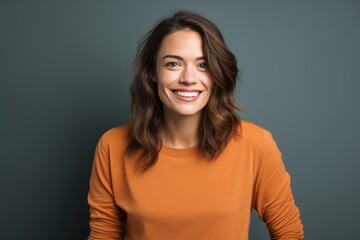 portrait of a smiling woman in her 30s sporting a long-sleeved thermal undershirt isolated on solid 