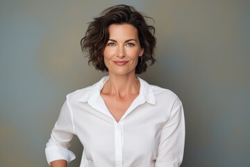 Sticker - Portrait of a satisfied woman in her 40s wearing a classic white shirt while standing against solid color backdrop