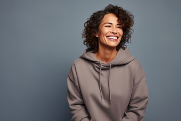 Canvas Print - Portrait of a grinning woman in her 40s dressed in a comfy fleece pullover while standing against solid color backdrop