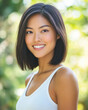 © Taras Vykhopen - Beautiful Asian woman smiling outdoors in a white tank top with a vibrant background