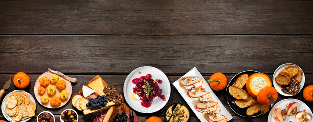 Aufkleber - Autumn theme appetizer bottom border against a dark wood banner background. Charcuterie board, pumpkin and apple dips, crostini, cheeses and snacks. Top view.