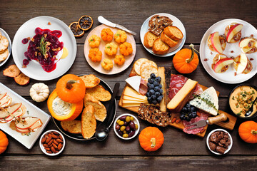 Sticker - Fall theme appetizer table scene against a dark wood background. Charcuterie board, pumpkin and apple dips, crostini, cheeses and snacks. Top view.