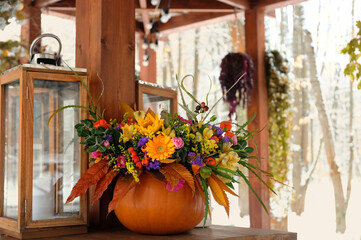 Sticker - autumn background. beautiful floral bouquet in pumpkin on garden table. decorative composition with flowers in pumpkin vase for autumn season, thanksgiving, halloween. fall decor