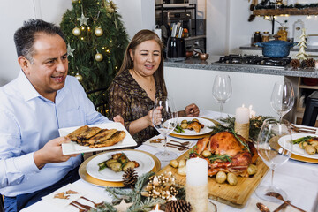 Wall Mural - Mexican senior couple having Christmas dinner at home in Mexico Latin America, hispanic family mother and father in holidays