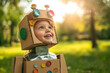 © Alexandra - Cheerful child wearing a robot costume made of cardboard boxes is having fun outdoors