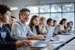 © mertingen - Mature professor teaching a diverse group of students in a classroom