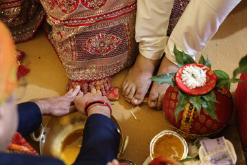 An Indian wedding ceremony, where the bride and groom's feet are blessed, symbolizing purity, respect, and the union of two souls in traditional rituals.