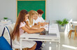 © Studio Romantic - Schoolchildren sit in computer classroom learning with laptops. Modern technology in learning to education where learning is intertwined with technology Pupils sitting in classroom with laptops