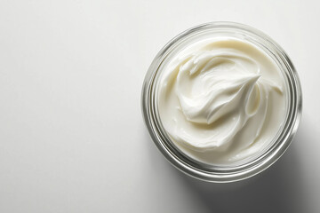 Wall Mural - open glass jar of white skincare cream product against white background.