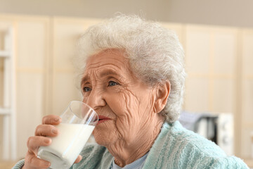 Poster - Senior woman drinking milk in kitchen, closeup