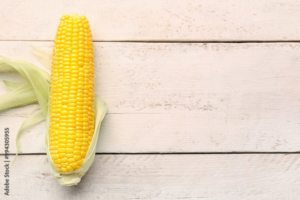 Fresh corn cob on white wooden background