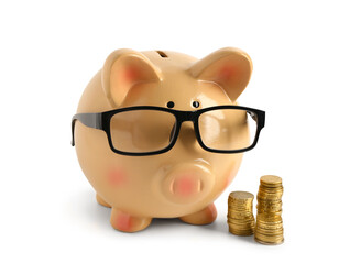 Orange piggy bank in eyeglasses with coins isolated on white background