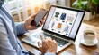 © evastar - Engaged in online shopping, an individual browses through various clothing and accessory options on a laptop while holding a smartphone in a café, enjoying their coffee
