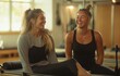 © Georgii - Two women laughing and enjoying a Pilates workout session on a Reformer machine in a bright and sunny gym studio