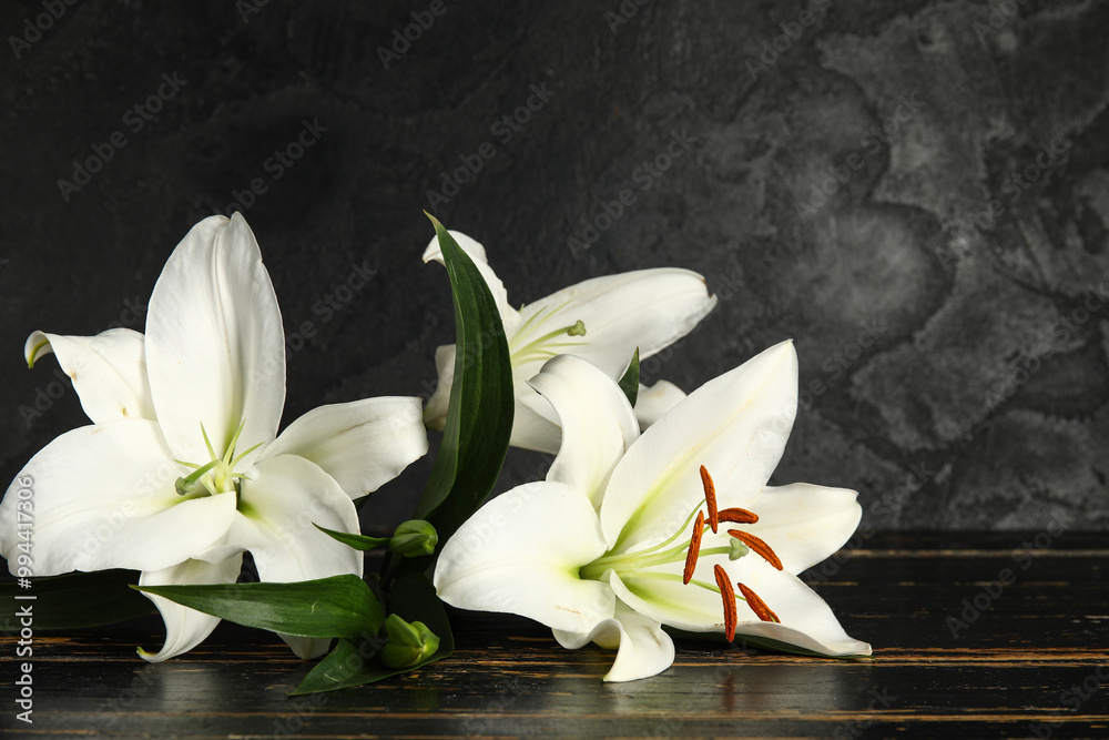 White lily flowers on dark wooden table